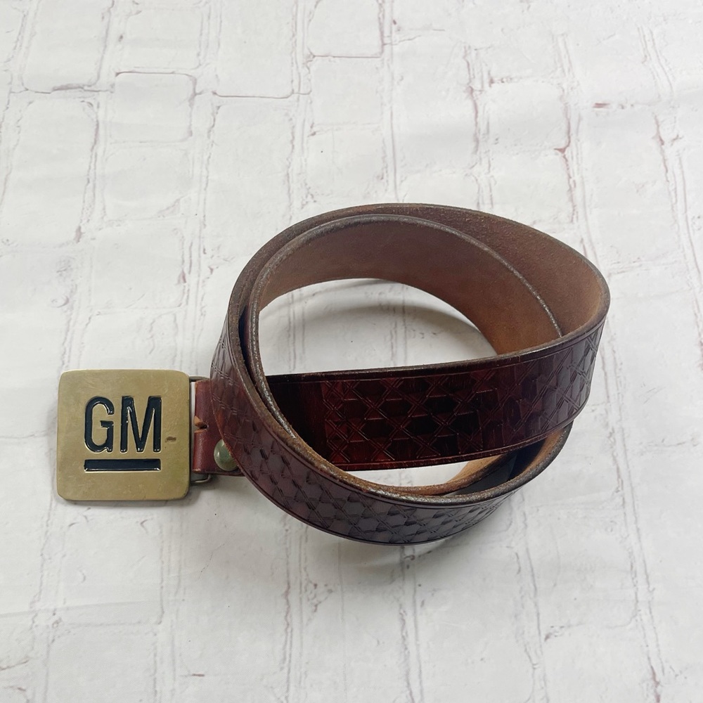 Vintage GM brass belt buckle on brown woven leather belt